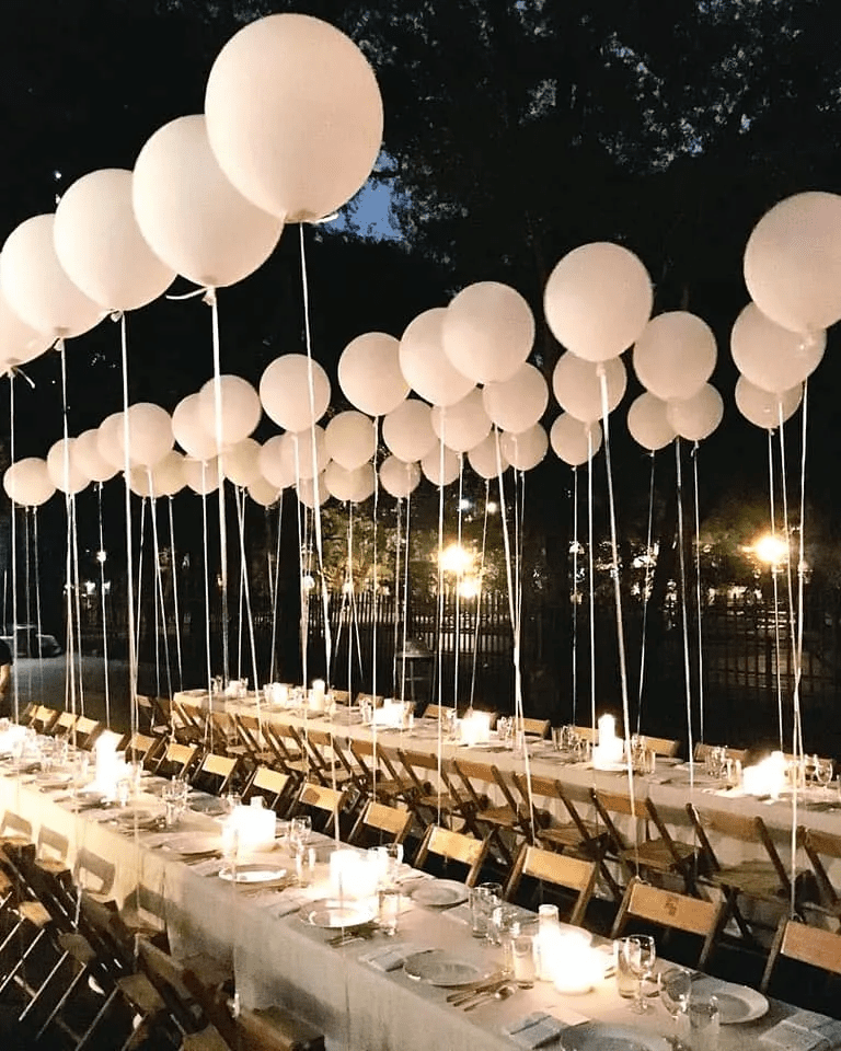 Banquete elegante con globos en cada silla.